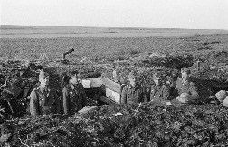Группа немецких солдат возле входа в блиндаж в окопе в Белгородской области. На бруствере лежит противотанковая мина. Источник: http://waralbum.ru.